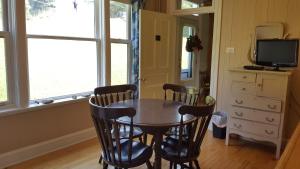 a dining room with a table and chairs and a television at Le Manoir du Vieux Presbytère in Port-Daniel +22 photos