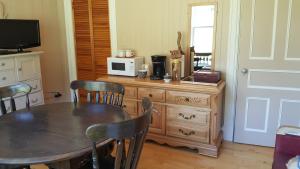 a dining room with a table and a microwave at Le Manoir du Vieux Presbytère in Port-Daniel