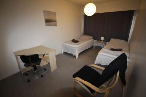 a room with two beds and a desk and chairs at MajoitusYkkönen in Raahe