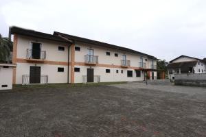 Un grand bâtiment blanc avec de nombreuses fenêtres dans l'établissement Hotel Schroeder, à Pomerode