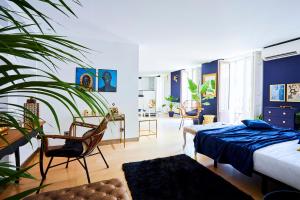 マドリードにあるRoyal Palace Gran Via Boutiqueの青い壁のベッドルーム1室、ベッド1台、植物が備わります。