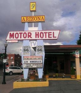 Arizona 9 Motor Hotel في ويليامز: لافتة الفندق للسيارات أمام متجر