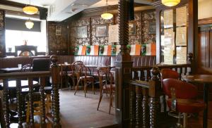 a restaurant with a bar with chairs and tables at JBs Bar & Guest Accommodation in Kilkenny