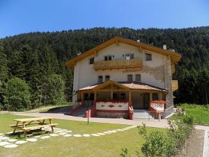 a large building with a picnic table in front of it at Genzianella Molveno-Andalo in Molveno