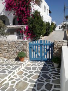 um portão azul numa rua com flores em Minas House Antiparos em Antiparos Town