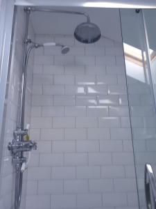 a shower in a bathroom with white tiles at Field View B&B in Eastrington +35 photos