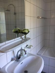 a white bathroom with a sink and a mirror at Lonestar Appartement in Burgh Haamstede
