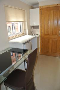 cocina con escritorio, fregadero y puerta en Seven Dials Apartments Bedford Street, en Londres