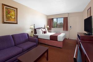 um quarto de hotel com uma cama e um sofá em Howard Johnson by Wyndham Red Deer em Red Deer