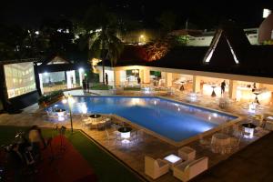 una gran piscina por la noche con gente de pie alrededor en Best Western Plus Hotel Terraza en San Salvador