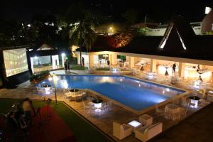 una gran piscina por la noche con gente de pie alrededor en Best Western Plus Hotel Terraza, en San Salvador