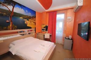 a bedroom with a large painting on the wall at Black Sea Star Batumi in Batumi