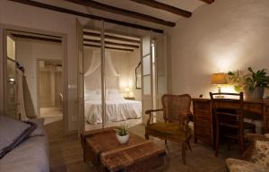 a living room with a bed and a desk and a table at El Jardinet de Sant Esteve in Olot +114 photos