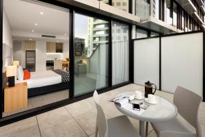シドニーにあるクエスト セント レナーズのベッド、テーブル、椅子が備わる客室です。