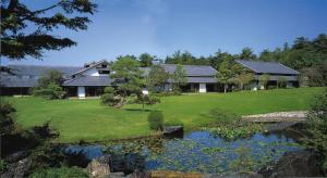 Yamaha Resort Katsuragi Kitanomaru في Fukuroi: منزل أمامه بركة
