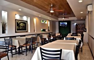 a restaurant with tables and chairs and a bar at Hotel Royal Inn in Monclova