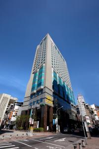 ein hohes Glasgebäude in einer Stadtstraße in der Unterkunft Taisugar Hotel Taipei in Taipeh