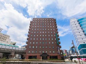 Un alto edificio marrone nel centro di una città di Nishitetsu Inn Tenjin a Fukuoka