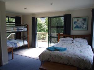 sypialnia z łóżkiem i balkonem w obiekcie Anakiwa Lodge w mieście Anakiwa