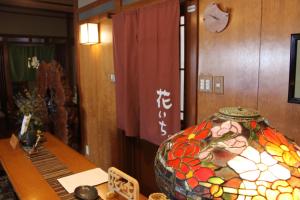 una habitación con una mesa con un jarrón encima en Hanaichi, en Tsumagoi