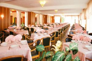 ein Zimmer mit Tischen und Stühlen mit rosa Tischen und Stühlen in der Unterkunft Park Hotel Jolanda in San Zeno di Montagna