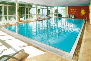 a large blue swimming pool in a building at Park Hotel Jolanda in San Zeno di Montagna