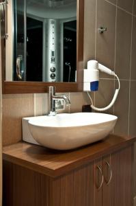 W łazience znajduje się biała umywalka i lustro. w obiekcie Simre Hotel w mieście Amasya