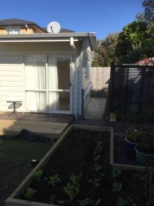 a backyard with a wooden deck and a house at K&R Orewa homestay in Orewa