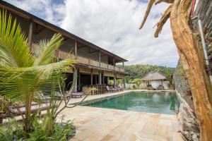 a villa with a swimming pool and a resort at Baha Baha Villas West Sumbawa - Sk8, Gym, Sauna & Spas Hot & Cold, Bar & Restaurant in Sekongkang