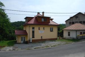 ein Haus mit rotem Dach an der Straßenseite in der Unterkunft Apartmánový Dom Králiky in Králiky