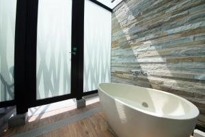 a bath tub in a bathroom with a large window at HOTEL Cargo Shinsaibashi in Osaka