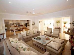 a large living room with couches and a table at Fairlight Beach House in Umdloti
