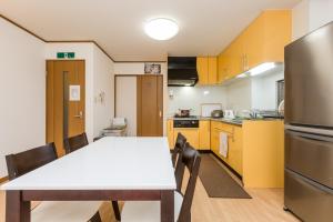 a kitchen and dining room with a table and chairs at Awaza House 2 in Osaka