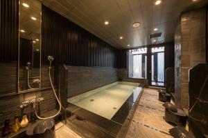 a bathroom with a swimming pool and a shower at HOTEL Cargo Shinsaibashi in Osaka