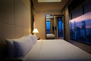 a bedroom with a bed with a view of a city at Dorsett Kuala Lumpur in Kuala Lumpur