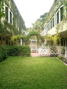 un patio de un edificio con césped y plantas en Hotel Coranda, en Colima