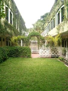 a courtyard of a building with grass and plants at Hotel Coranda in Colima