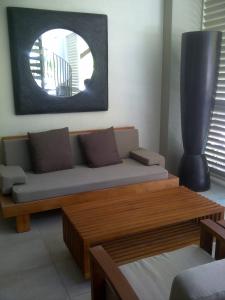 a living room with a couch and a mirror at Penthouse 239 at Sea Temple Port Douglas in Port Douglas