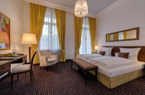 ein Hotelzimmer mit einem großen Bett und einem Schreibtisch in der Unterkunft Hotel am Sophienpark in Baden-Baden