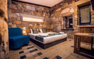 a bedroom with a bed and a blue chair at Keros Blue - Luxury in Wilderness in Kalliópi