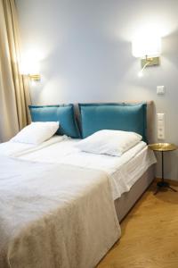 2 Betten in einem Schlafzimmer mit blauem Kopfteil in der Unterkunft Guest House Senasis Pastas in Druskininkai