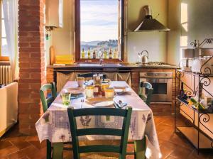 a kitchen with a table with chairs and a window at Borgo Fajani in Terricciola
