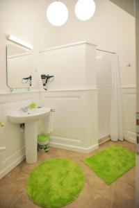 a bathroom with a sink and a green rug at Várkapitány Apartman Eger in Eger