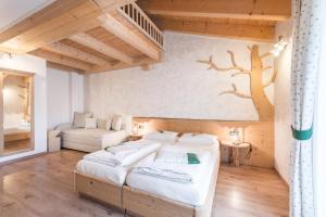 een slaapkamer met 2 bedden en een muurschildering van bomen aan de muur bij Agritur La Val in Vigolo Vattaro +5 foto's