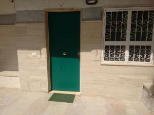 a green door on the side of a building at Casa Lucrino in Pozzuoli +15 photos