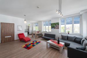 ein Wohnzimmer mit einem Sofa und einem roten Stuhl in der Unterkunft Café & mehr in Halle an der Saale