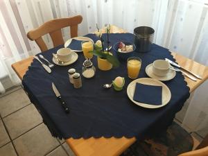 uma mesa com uma toalha de mesa azul e pratos e bebidas em Hotel Gästehaus Sonne em Sinsheim