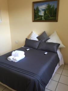 a bed with two towels on top of it at The Norwegian Lodge in Umkomaas