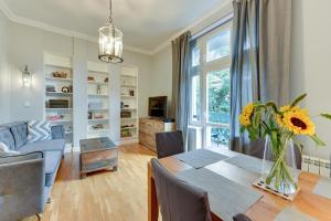 un salon avec une table et un vase de fleurs dans l'établissement Lion Apartments - Hampton Family Apartment with two bedrooms, à Sopot