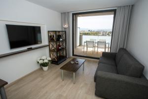 a living room with a couch and a tv and a table at ApartHotel Playa Oliva in Oliva
